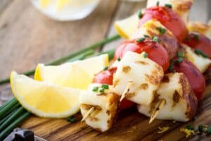 three halloumi cheese and tomato skewers with lemon