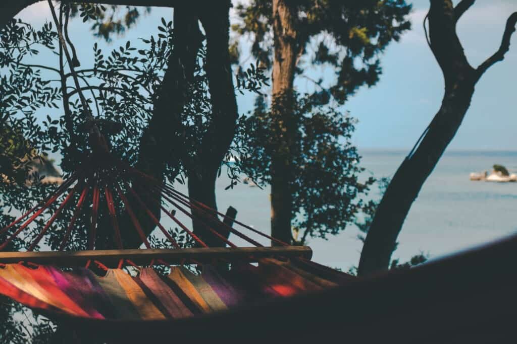 a hammock hanging on the trees at a beach site
