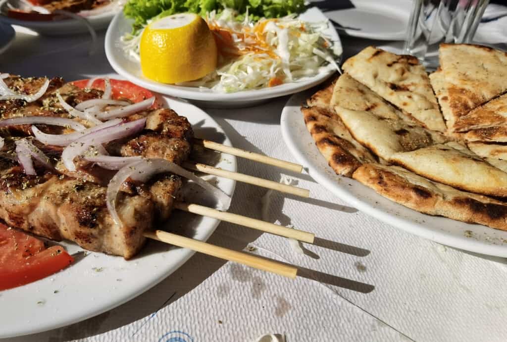 souvlaki meat in the plate with pita tomato and onion, traditonal food in greece